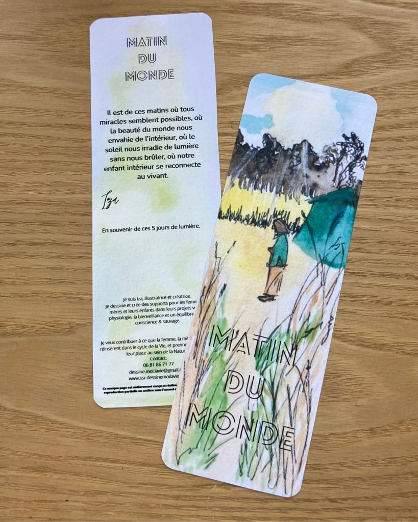 La marque-pages "Matin du monde" est vu du recto, et verso. Il est posé sur un support en bois. 