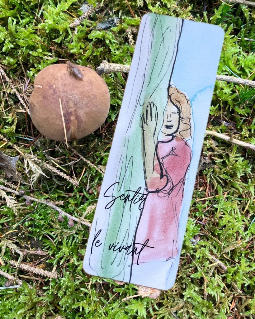 Le marque-pages "Sentir le vivant" est vu de recto, sur un fond de nature: mousse et champignon.